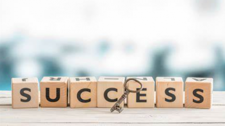 The word success is spelt out in wooden blocks with a key next to them.