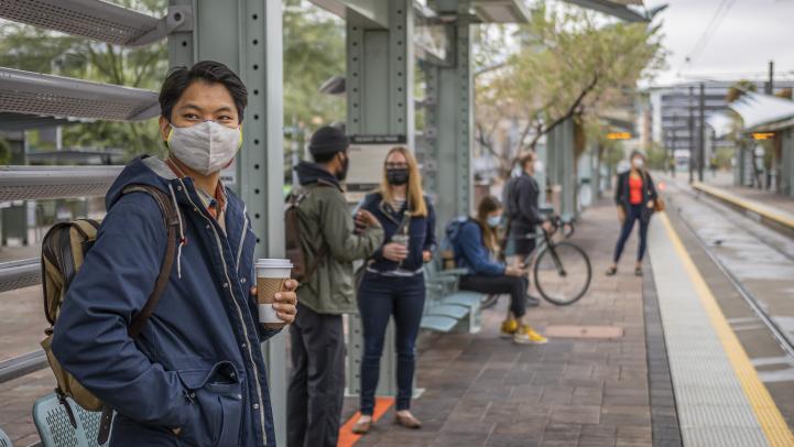 Rider with mask waiting for the bus at Tempe Transportation Center