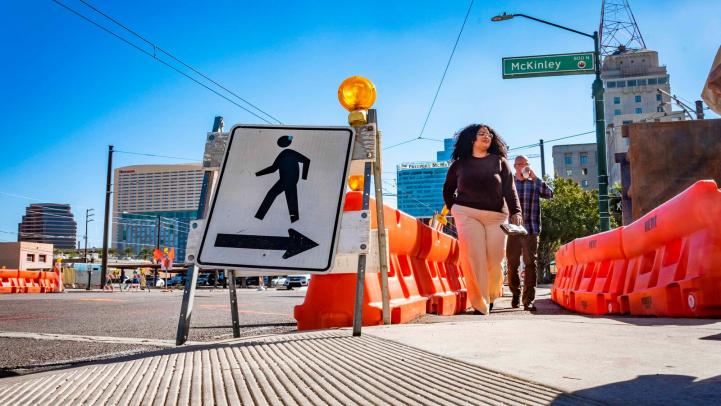 Peatones caminando por la zona de construcción en McKinley Street y Central Avenue.