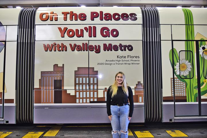 Kate Flores stands in front of the light rail train with her design