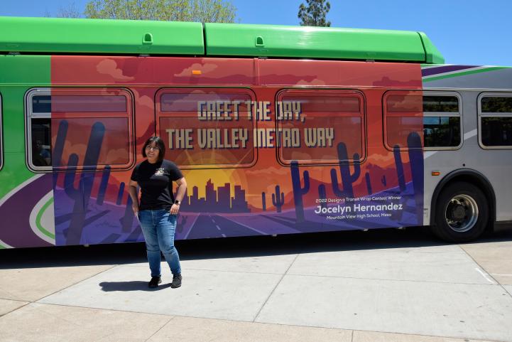 Jocelyn Hernandez stands in front of the bus with her design