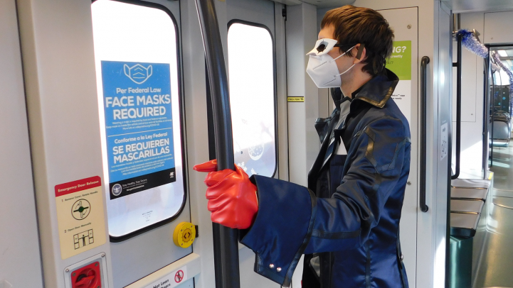 Cosplayer standing on light rail train