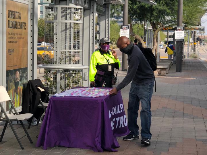 Customers at face covering giveaway table