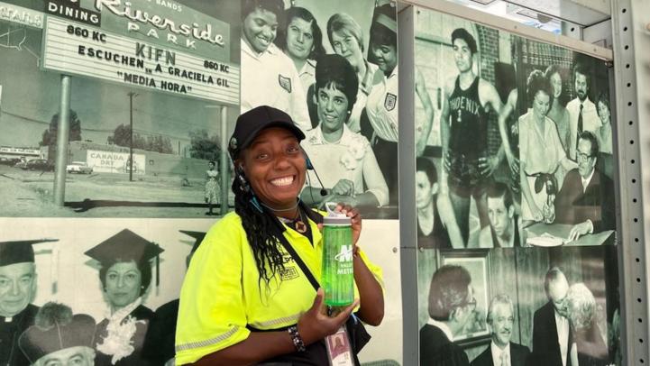 A customer experience coordinator holds up a water bottle