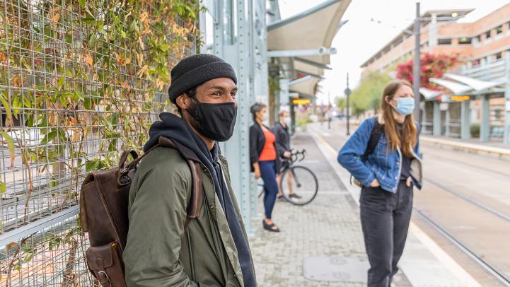 Passengers wearing masks and waiting for a light rail train