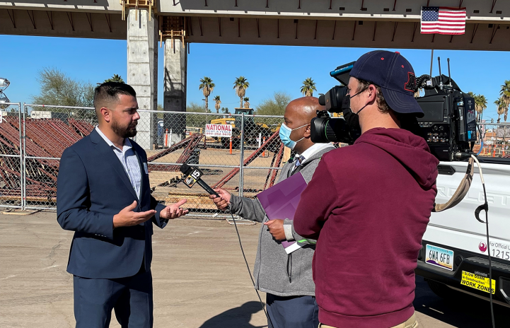 staff member interviewed on camera by news reporter