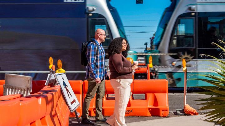 People walking next to a passing light rail train