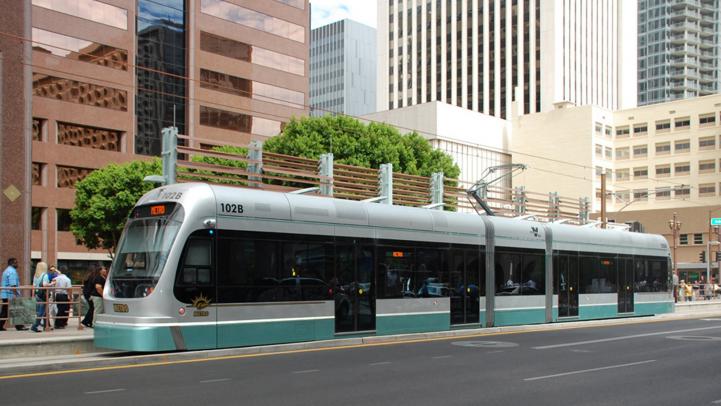 Light rail train in front of buildings