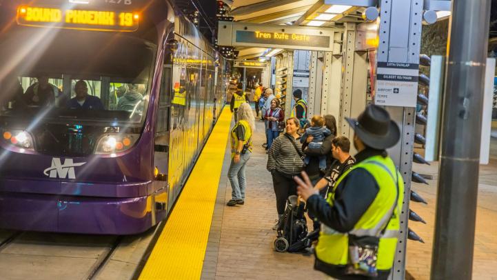 Valey Metro employees and riders on platform as train approaches