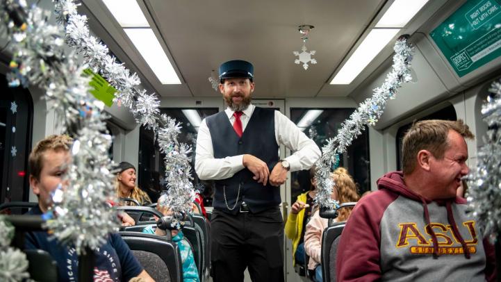 Riders inside Holiday decorated light rail train